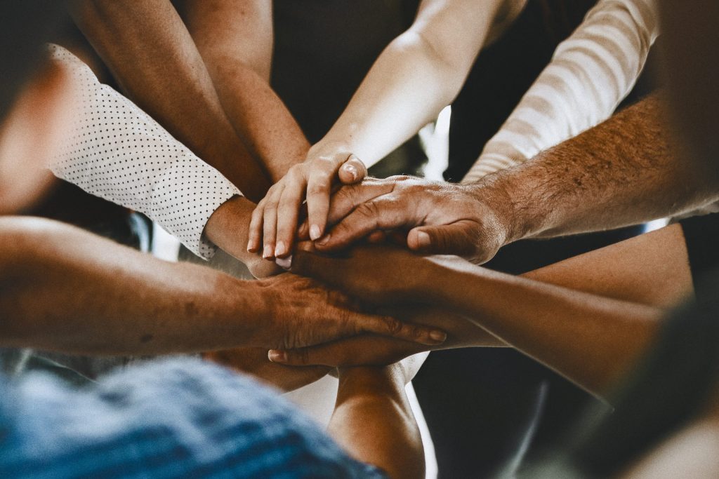 A diverse group putting their hands together in a circle.